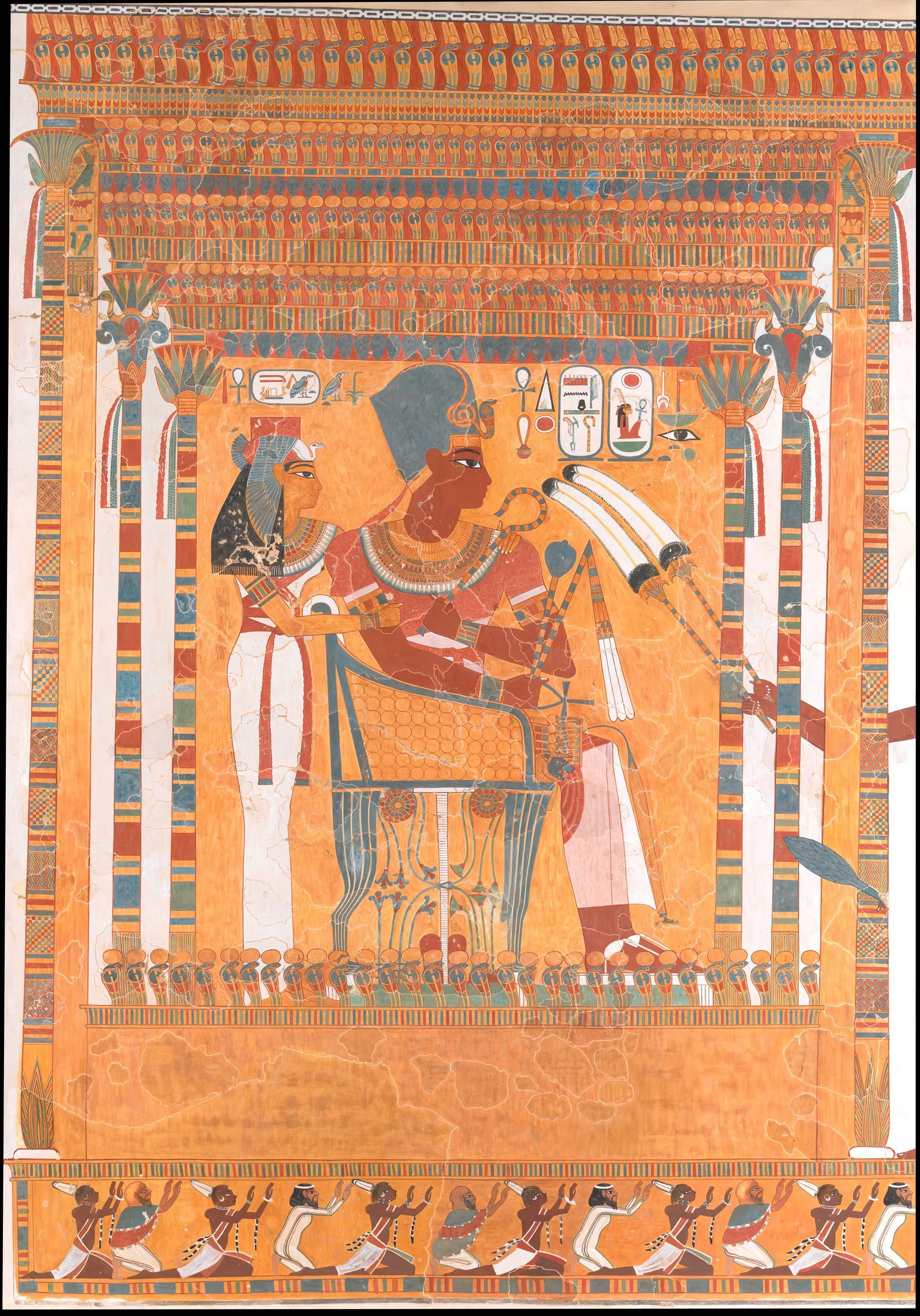 A 1914 tempera facsimile of a Theban tomb painting from Amenhotep III's reign: the king sits inside a brightly painted kiosk beside his mother Mutemwia, both in white pleated linen, rendered in bands of orange, blue and green with a decorated canopy above and a row of figures along the base.