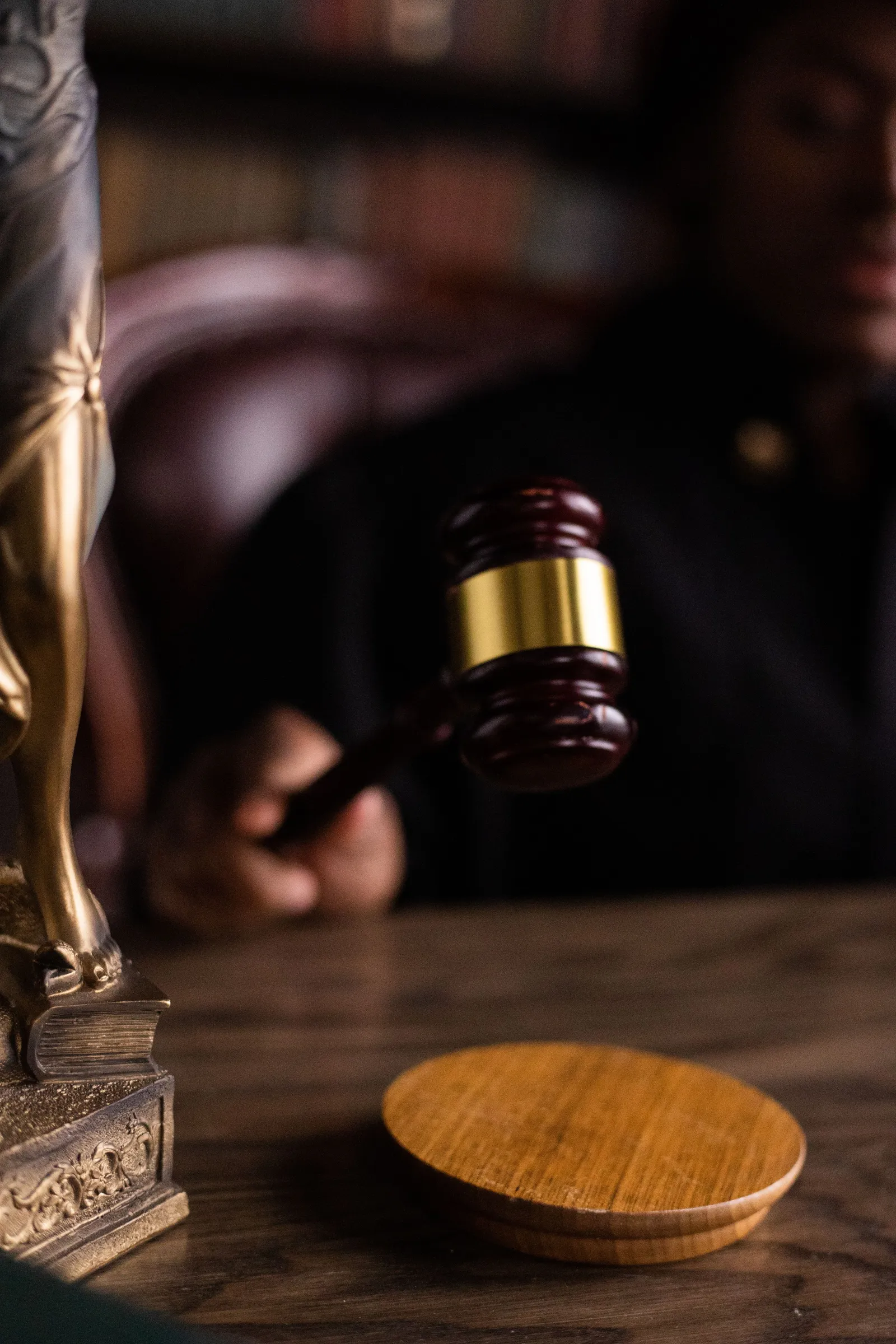 Close-up of a judge's gavel resting on a wooden block.