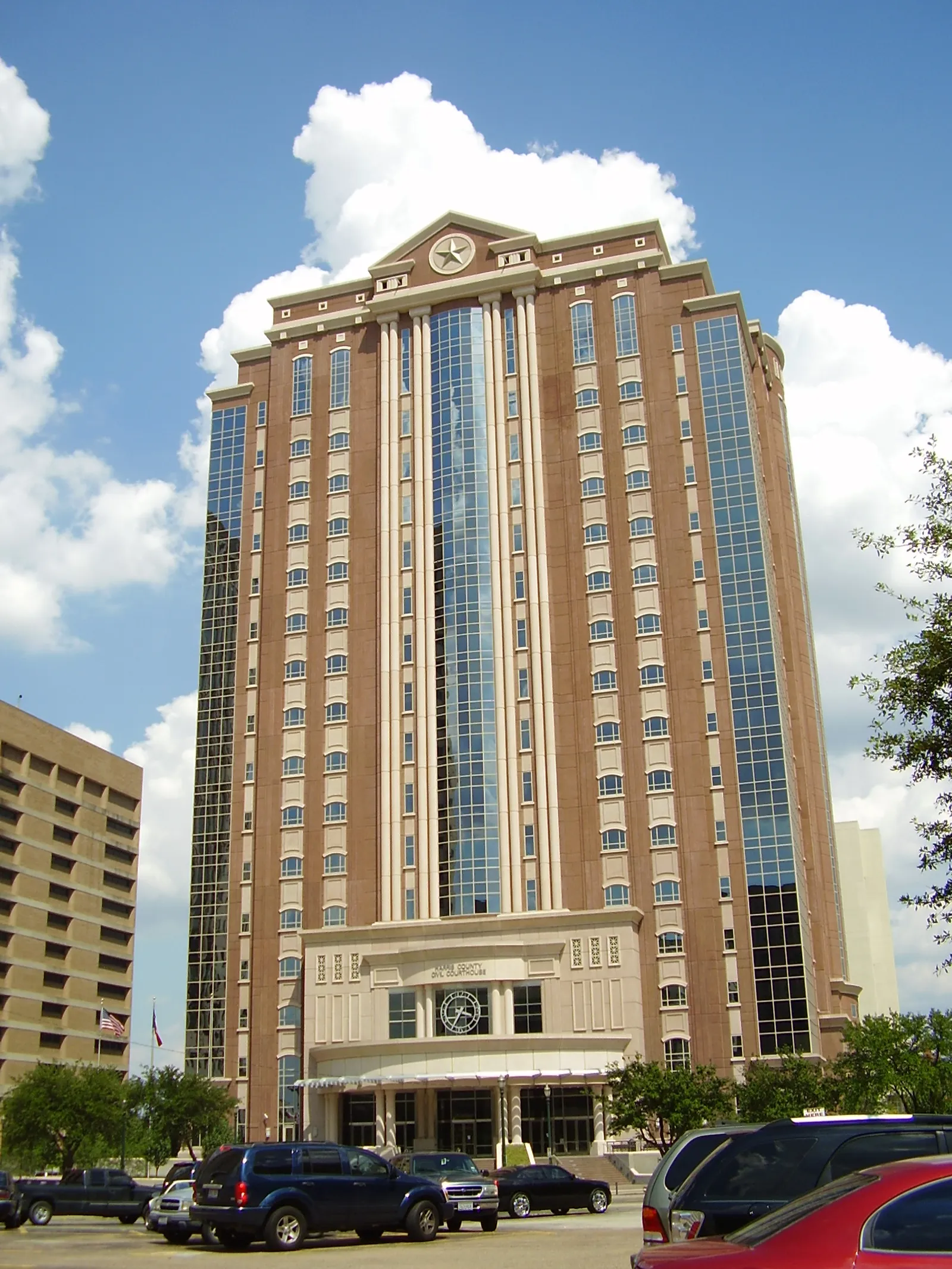 The Harris County Civil Courthouse in downtown Houston, a tall brick-and-stone tower with a Texas star set into its pediment; the entrance below is lettered HARRIS COUNTY CIVIL COURTHOUSE.