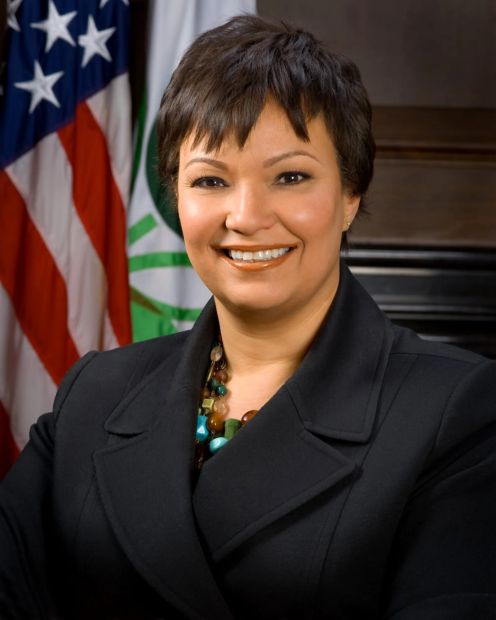 Official EPA head-and-shoulders portrait of Lisa P. Jackson, smiling in a dark blazer and beaded necklace in front of an American flag and the EPA seal.