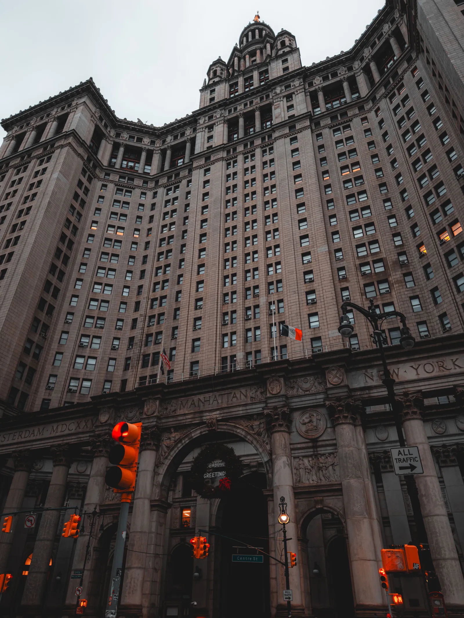 New York City Hall photographed from a low angle, showing its columned facade, arched windows and cupola rising against the sky.