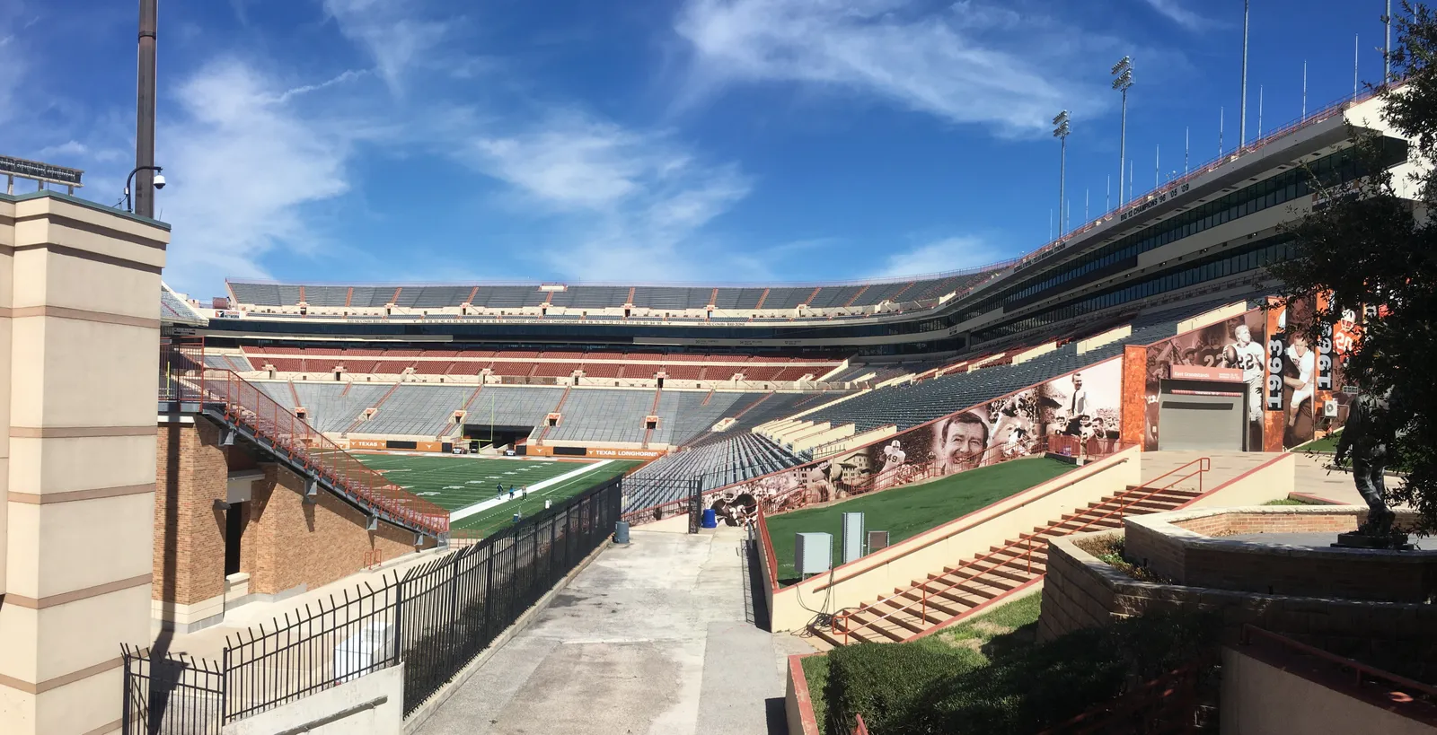 An elevated daytime view of the empty seating bowl and field at Darrell K Royal-Texas Memorial Stadium, showing the stadium's tiered stands and structure with no game in progress.