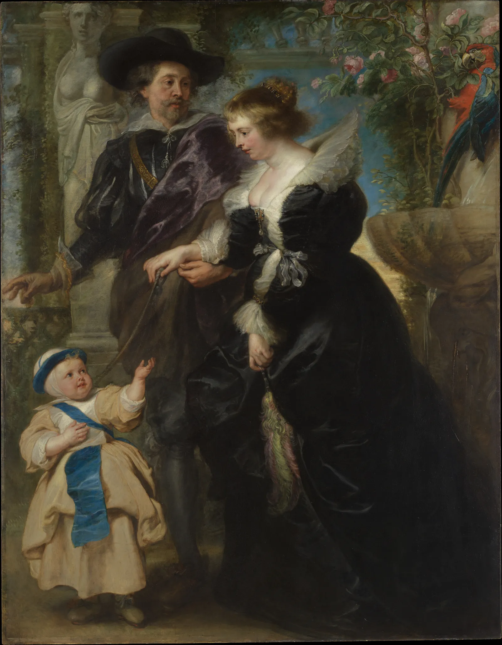 Rubens's own family portrait, painted in oil on wood around 1635: the artist in a wide black hat and purple cloak stands in a garden beside his second wife, Helena Fourment, who wears an elaborate black silk gown with a white fur-trimmed collar and a jewelled band in her fair hair. Their infant son Frans reaches up from the left in a pale gown and blue sash, and a red-and-blue macaw perches on a rose-covered arbour at the right.