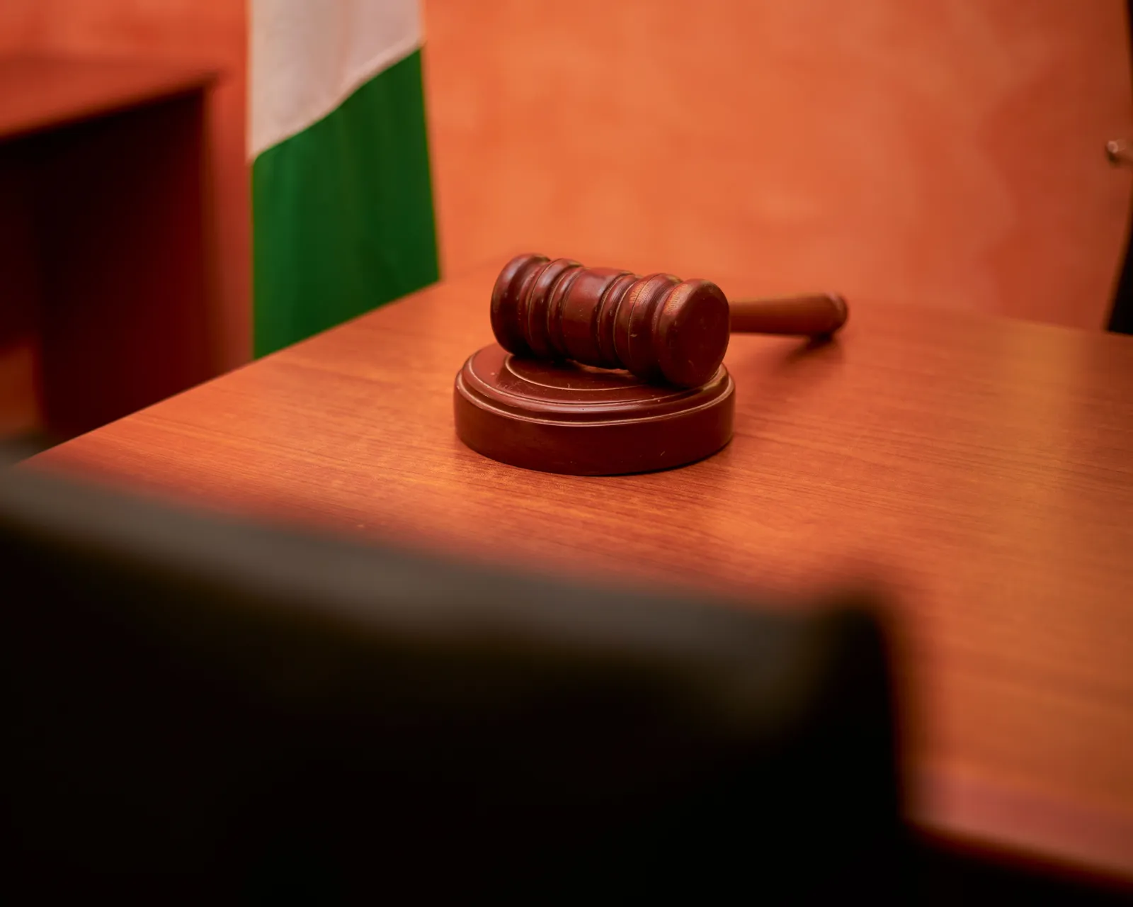 A wooden gavel resting on its sound block on a courtroom desk.